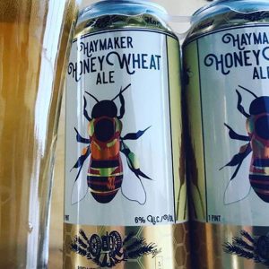 Haymaker Honey Wheat cans with large bee in the center